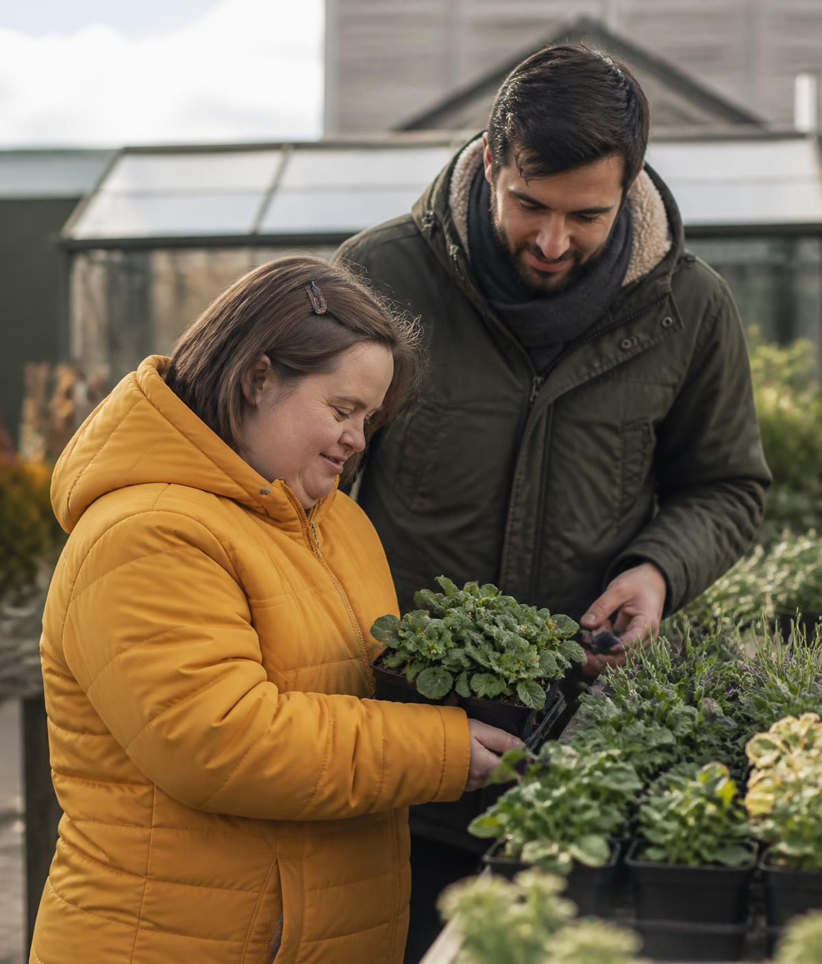 A woman choosing plants with support during a community outing